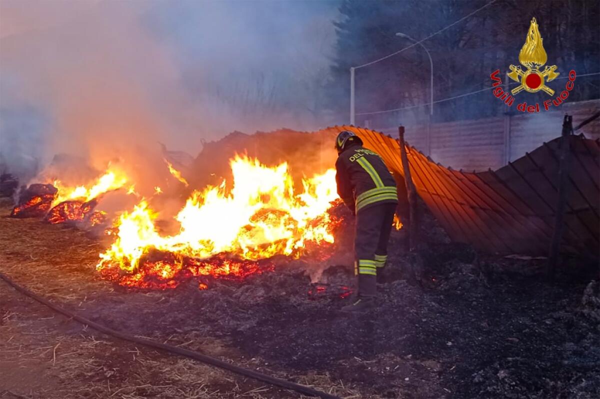 In fiamme deposito agricolo con rotoballe di paglia e fieno - 