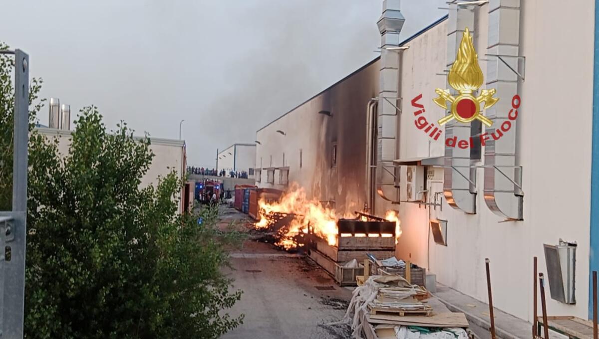 In fiamme alcuni cassoni in legno all'esterno di una fabbrica - 
